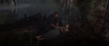 Movie still from “Nevada Smith” (1966), directed by Henry Hathaway – A man and a woman are sitting on the ground in the woods; Wide shot, High angle