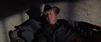 Movie still from “Nevada Smith” (1966), directed by Henry Hathaway – A man wearing a cowboy hat is laying on the ground; Medium shot, Low angle