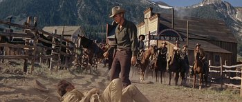 Movie still from “Nevada Smith” (1966), directed by Henry Hathaway – A man in a cowboy hat is standing in front of a group of people; Wide shot, Low angle