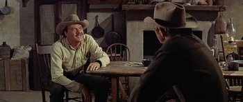 Movie still from “Nevada Smith” (1966), directed by Henry Hathaway – A man sitting at a table with another man in front of him; Medium shot, Over the shoulder angle