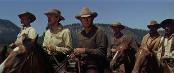 Movie still from “Nevada Smith” (1966), directed by Henry Hathaway – A group of men riding horses on a dirt road; Medium shot, Low angle