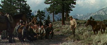 Movie still from “Nevada Smith” (1966), directed by Henry Hathaway – A group of men standing on top of a grass covered hill; Wide shot, High angle
