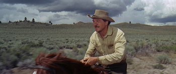 Movie still from “Nevada Smith” (1966), directed by Henry Hathaway – A man in a cowboy hat is sitting on a horse; Medium shot, Low angle