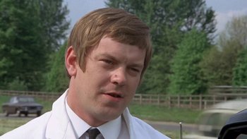 Movie still from “O Lucky Man!” (1973), directed by Lindsay Anderson – A person wearing a suit and tie; Close Up shot, Low angle