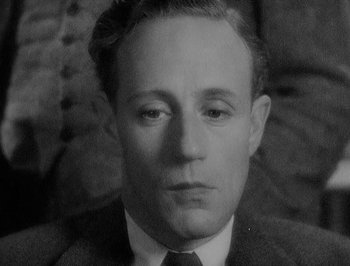 Movie still from “Of Human Bondage” (1934), directed by John Cromwell – An old black and white photo of a man in a suit and tie; Close Up shot, High angle
