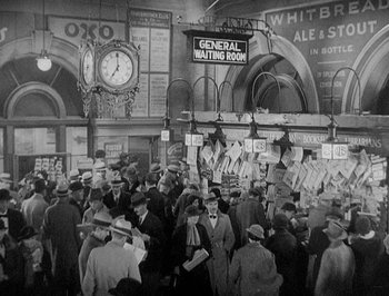 Movie still from “Of Human Bondage” (1934), directed by John Cromwell – A crowd of people standing in front of a clock; Extreme Wide shot, High angle