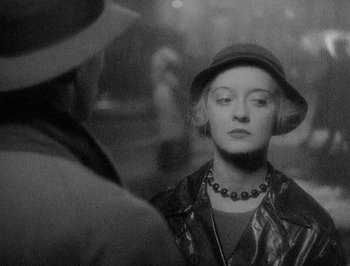 Movie still from “Of Human Bondage” (1934), directed by John Cromwell – A woman wearing a hat looking at the camera; Close Up shot, Over the shoulder angle
