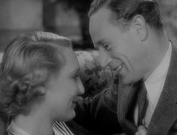 Movie still from “Of Human Bondage” (1934), directed by John Cromwell – An old photo of a man and a woman smiling at each other; Close Up shot, High angle
