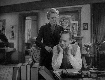 Movie still from “Of Human Bondage” (1934), directed by John Cromwell – An older woman standing next to a man in a room; Medium shot, High angle