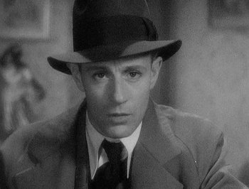 Movie still from “Of Human Bondage” (1934), directed by John Cromwell – A man wearing a hat and a suit; Close Up shot, High angle