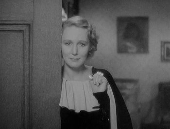 Movie still from “Of Human Bondage” (1934), directed by John Cromwell – An old photo of an older woman in a black dress; Close Up shot, High angle