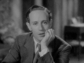 Movie still from “Of Human Bondage” (1934), directed by John Cromwell – An old photo of a man in a suit and tie; Close Up shot, High angle