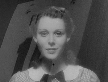 Movie still from “Of Human Bondage” (1934), directed by John Cromwell – An old black and white photo of a woman with a bow tie; Close Up shot, Low angle