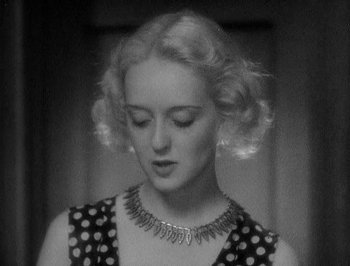 Movie still from “Of Human Bondage” (1934), directed by John Cromwell – A black and white photo of a woman in a polka dot dress; Close Up shot, High angle