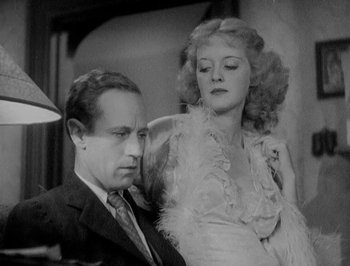 Movie still from “Of Human Bondage” (1934), directed by John Cromwell – A man and a woman sitting next to each other in a room; Medium shot, Low angle
