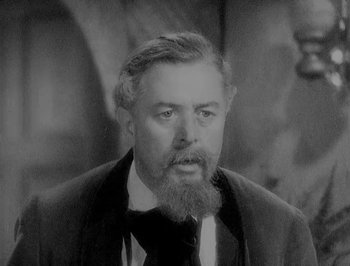 Movie still from “Of Human Bondage” (1934), directed by John Cromwell – An old photo of a man with a long beard; Close Up shot, High angle