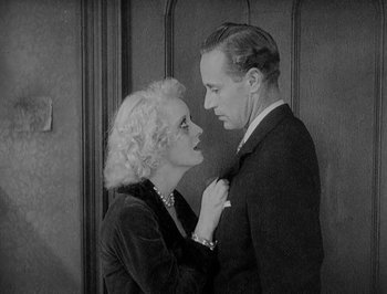 Movie still from “Of Human Bondage” (1934), directed by John Cromwell – An old photo of a man and a woman looking at each other; Medium shot, High angle