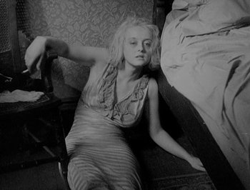 Movie still from “Of Human Bondage” (1934), directed by John Cromwell – A woman laying on the ground in a room; Medium shot, High angle