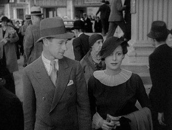 Movie still from “Of Human Bondage” (1934), directed by John Cromwell – A man and a woman walking down a street; Medium shot, High angle