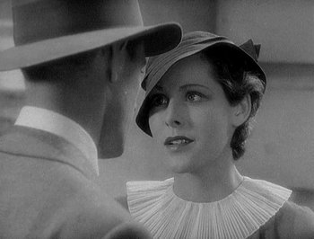Movie still from “Of Human Bondage” (1934), directed by John Cromwell – An old photo of a man and a woman looking at each other; Close Up shot, Over the shoulder angle