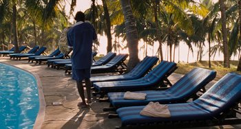 Movie still from “Paradise: Love” (2012), directed by Ulrich Seidl – A person standing in front of a row of lounge chairs; Wide shot, High angle