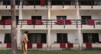 Movie still from “Paradise: Love” (2012), directed by Ulrich Seidl – A man standing in front of an apartment building; Extreme Wide shot, High angle