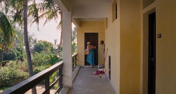 Movie still from “Paradise: Love” (2012), directed by Ulrich Seidl – A woman in a blue dress is walking down a hallway; Extreme Wide shot, High angle