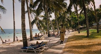 Movie still from “Paradise: Love” (2012), directed by Ulrich Seidl – A man standing on the beach next to the ocean; Extreme Wide shot, High angle