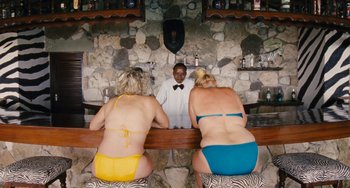 Movie still from “Paradise: Love” (2012), directed by Ulrich Seidl – Two women and a man are sitting at a bar; Wide shot, High angle