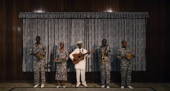 Movie still from “Paradise: Love” (2012), directed by Ulrich Seidl – A group of people dressed in animal print outfits; Wide shot, Low angle