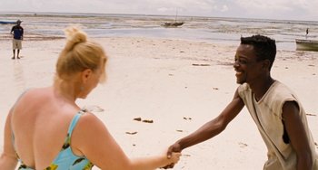 Movie still from “Paradise: Love” (2012), directed by Ulrich Seidl – A man and a woman holding hands on the beach; Wide shot, High angle