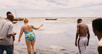 Movie still from “Paradise: Love” (2012), directed by Ulrich Seidl – Two people standing in the water near a boat; Wide shot, Over the shoulder angle