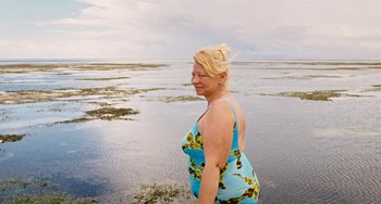 Movie still from “Paradise: Love” (2012), directed by Ulrich Seidl – A woman standing in the middle of the ocean; Medium shot, High angle