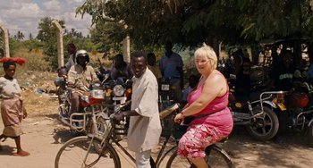 Movie still from “Paradise: Love” (2012), directed by Ulrich Seidl – A woman sitting on a bike next to a man on a bicycle; Wide shot, High angle