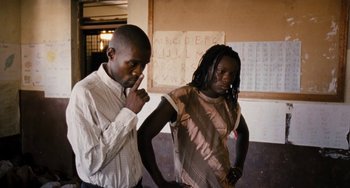 Movie still from “Paradise: Love” (2012), directed by Ulrich Seidl – Two people standing next to each other in a room; Medium shot, High angle