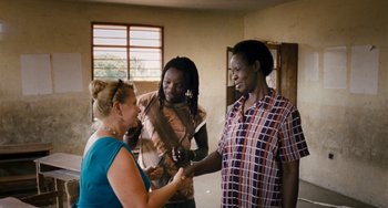 Movie still from “Paradise: Love” (2012), directed by Ulrich Seidl – Two women and a man are talking in a room; Medium shot, Over the shoulder angle