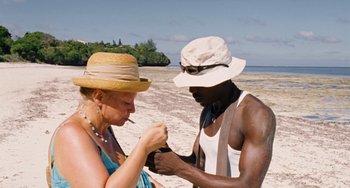 Movie still from “Paradise: Love” (2012), directed by Ulrich Seidl – A man and a woman on the beach looking at each other; Medium shot, High angle