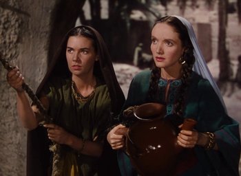 Movie still from “Samson and Delilah” (1949), directed by Cecil B. DeMille – Two women in medieval garb holding a jug; Medium shot, Low angle