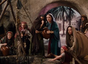 Movie still from “Samson and Delilah” (1949), directed by Cecil B. DeMille – A group of people standing next to each other in a cave; Wide shot, High angle