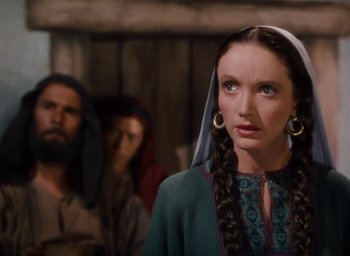 Movie still from “Samson and Delilah” (1949), directed by Cecil B. DeMille – A woman with long braids wearing a green dress; Close Up shot, Over the shoulder angle