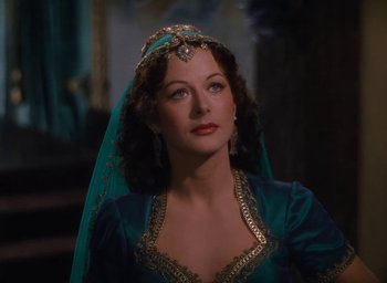 Movie still from “Samson and Delilah” (1949), directed by Cecil B. DeMille – A woman wearing a blue dress and a veil; Medium shot, Over the shoulder angle