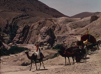 Movie still from “Samson and Delilah” (1949), directed by Cecil B. DeMille – A man riding a camel in the middle of the desert; Extreme Wide shot, Low angle