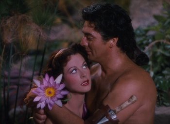 Movie still from “Samson and Delilah” (1949), directed by Cecil B. DeMille – A man and a woman embracing each other in the woods; Medium shot, High angle