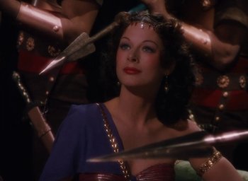 Movie still from “Samson and Delilah” (1949), directed by Cecil B. DeMille – A beautiful woman with long hair and a crown; Medium shot, Over the shoulder angle