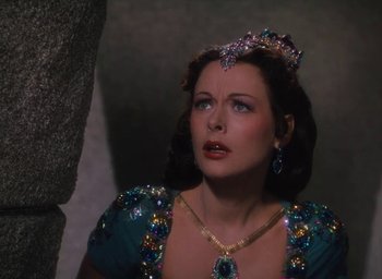 Movie still from “Samson and Delilah” (1949), directed by Cecil B. DeMille – A woman wearing a blue dress and a tiara; Close Up shot, Over the shoulder angle