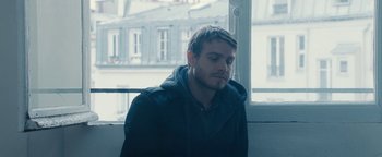 Movie still from “Simon Killer” (2012), directed by Antonio Campos – A young man is looking out of a window; Close Up shot, Over the shoulder angle