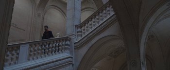 Movie still from “Simon Killer” (2012), directed by Antonio Campos – A person standing on top of an ornate staircase; Extreme Wide shot, Low angle