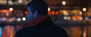 Movie still from “Simon Killer” (2012), directed by Antonio Campos – A man wearing a black jacket and a red scarf; Close Up shot, Over the shoulder angle