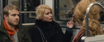 Movie still from “Simon Killer” (2012), directed by Antonio Campos – A woman sitting on a bus looking at her cell phone; Close Up shot, Over the shoulder angle