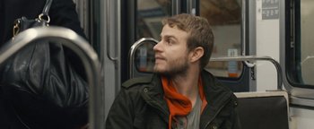 Movie still from “Simon Killer” (2012), directed by Antonio Campos – A man sitting on a bus with his head turned to the side; Close Up shot, Over the shoulder angle